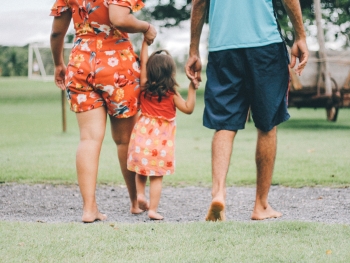 Woman and man holding young girls hand