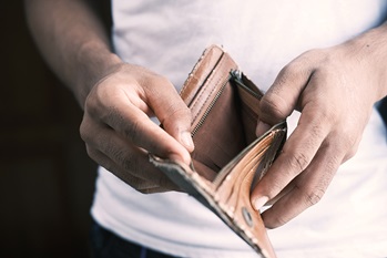 Man opening wallet with no money in it